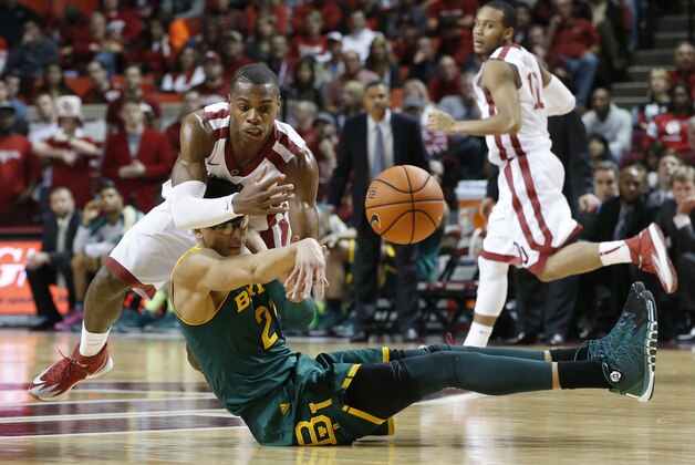Baylor center Isaiah Austin, bottom, passes the ball in front of Oklahoma guard Buddy Hield in the second half of an NCAA college basketball game in Norman, Okla., Saturday, Feb. 8, 2014. Oklahoma won 88-72. Oklahoma guard Jordan Woodard(10) looks on. (AP Photo/Sue Ogrocki)