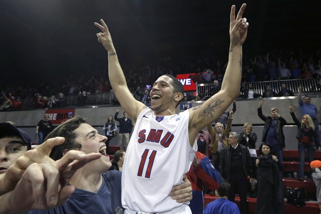 SMU guard Nic Moore (11) celebrates with fans on the court after the NCAA college basketball game against Cincinnati  Saturday, Feb. 8, 2014, in Dallas.  SMU won 76-55. (AP Photo/LM Otero)