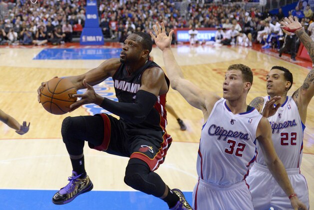 Miami Heat guard Dwyane Wade, left, goes up for a shot as Los Angeles Clippers forward Blake Griffin, center and forward Matt Barnes defend during the first half of an NBA basketball game, Wednesday, Feb. 5, 2014, in Los Angeles. (AP Photo/Mark J. Terrill)