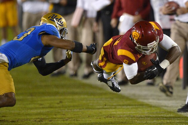 Southern California wide receiver Marqise Lee, right, dives for extra yards as UCLA cornerback Anthony Jefferson defends during the second half of an NCAA college football game, Saturday, Nov. 30, 2013, in Los Angeles. UCLA won 35-14. (AP Photo/Mark J. Terrill)