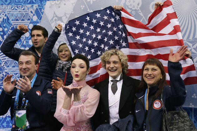Meryl Davis and Charlie White of the United States, centre, wait for their results after competing in the team ice dance short dance figure skating competition at the Iceberg Skating Palace during the 2014 Winter Olympics, Saturday, Feb. 8, 2014, in Sochi, Russia. (AP Photo/Darron Cummings, Pool)