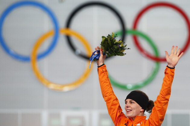 Ireen Wust of the Netherlands celebrates winning gold during the flower ceremony for the women's 3,000-meter speedskating race at the Adler Arena Skating Center during the 2014 Winter Olympics, Sunday, Feb. 9, 2014, in Sochi, Russia.  (AP Photo/Pavel Golovkin)