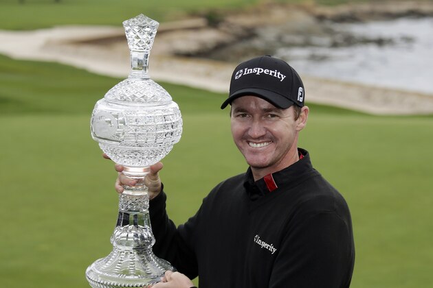 Jimmy Walker poses with his trophy on the 18th green of the Pebble Beach Golf Links after winning the AT&T Pebble Beach Pro-Am golf tournament Sunday, Feb. 9, 2014, in Pebble Beach, Calif. Walker shot a 2-over-par 74 to finish at total 11-under-par. (AP Photo/Eric Risberg)