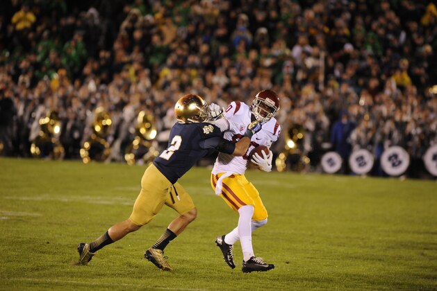 Southern California De'Von Flournoy makes a catch as Notre Dame Bennett Jackson makes the tackle during the 14-10 Notre Dame victory in a game Saturday Oct. 19, 2013 in South Bend, Ind. (AP Photo/Joe Raymond)