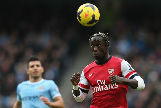 MANCHESTER, ENGLAND - DECEMBER 14:  Bacary Sagna of Arsenal in action watched by Sergio Aguero of Manchester City during the Barclays Premier League match between Manchester City and Arsenal at Etihad Stadium  on December 14, 2013 in Manchester, England.  (Photo by Clive Brunskill/Getty Images)