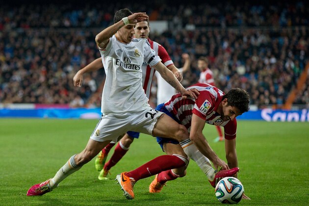 MADRID, SPAIN - FEBRUARY 05: Angel Di Maria (L) of Real Madrid CF competes for the ball with Raul Garcia (R) of Atletico de Madrid during the Copa del Rey semifinal first leg match between Real Madrid CF and Club Atletico Madrid at Estadio Santiago Bernabeu on February 5, 2014 in Madrid, Spain.  (Photo by Gonzalo Arroyo Moreno/Getty Images)