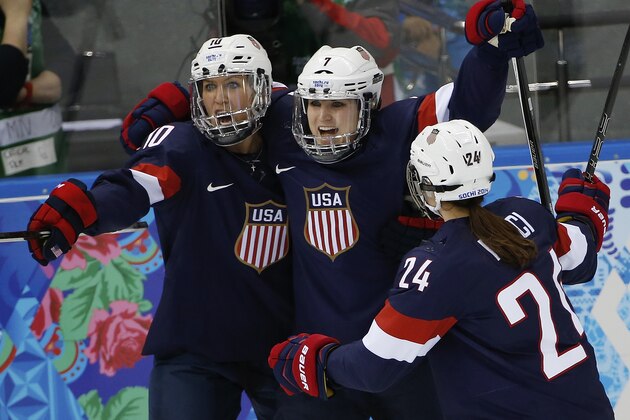 Meghan Duggan, Monique Lamoureux and Josephine Pucci of the Untied States (L-R) celebrate Lamoureux's goal against Switzerland during the 2014 Winter Olympics women's ice hockey game at Shayba Arena, Monday, Feb. 10, 2014, in Sochi, Russia. USA defeated Switzerland  9-0. (AP Photo/Petr David Josek)