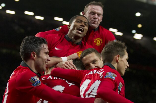 Manchester United's Michael Carrick, bottom centre left, celebrates with jubilant teammates after scoring against Fulham during their English Premier League soccer match at Old Trafford Stadium, Manchester, England, Sunday Feb. 9, 2014. (AP Photo/Jon Super)