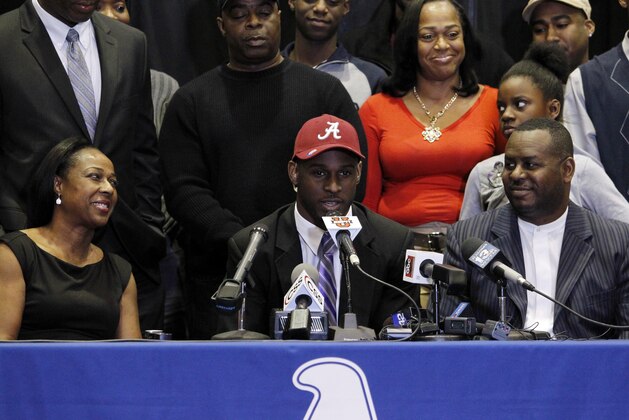Chenavis Evans, left, and Allan Evans, right, watch as their son Rashaan Evans speaks after the Auburn High School football player announces that he will attend Alabama during a national signing day ceremony on Wednesday, Feb. 5, 2014, in Auburn, Ala. (AP Photo/Butch Dill)