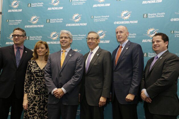 Dennis Hickey, new general manager for the Miami Dolphins football team, third from left, poses for a photo with team officials before being introduced at a news conference, Tuesday, Jan. 28, 2014, in Davie, Fla. Shown from left to right are CEO Tom Garfinkel, Executive Vice President for football operations Dawn Aponte, Hickey, owner Stephen Ross, head coach Joe Philbin, and vice chairman Matt Higgins. (AP Photo/Lynne Sladky)