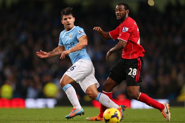 MANCHESTER, ENGLAND - JANUARY 18:  Sergio Aguero of Manchester City passes the ball as Kevin Theophile Catherine of Cardiff closes in during the Barclays Premier League match between Manchester City and Cardiff City at the Etihad Stadium on January 18, 2014 in Manchester, England.  (Photo by Alex Livesey/Getty Images)