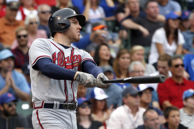 Atlanta Braves' Freddie Freeman watches his three-run home run off Chicago Cubs starting pitcher Scott Baker, also scoring Justin Upton and Jason Heyward, during the third inning of a baseball game Friday, Sept. 20, 2013, in Chicago. (AP Photo/Charles Rex Arbogast)