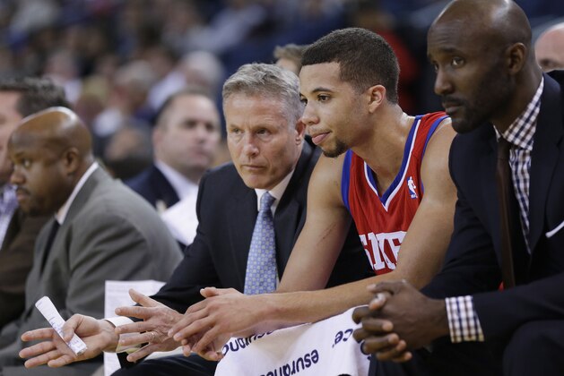Philadelphia 76ers head coach Brett Brown, left, talks to point guard Michael Carter-Williams, center, in the closing minutes of a 123-80 loss to the Golden State Warriors during the second half of an NBA basketball game on Monday, Feb. 10, 2014, in Oakland, Calif. (AP Photo/Marcio Jose Sanchez)