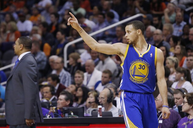 Golden State Warriors' Stephen Curry walks back to the bench as he gives instructions to his replacement during the second half of an NBA basketball game against the Phoenix Suns Saturday, Feb. 8, 2014, in Phoenix.  The Suns defeated the Warriors 122-109. (AP Photo/Ross D. Franklin)
