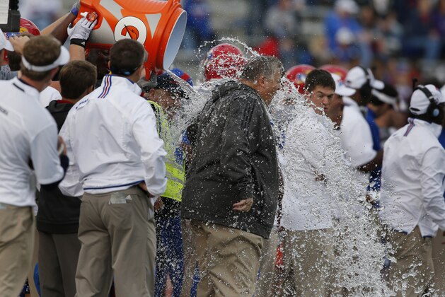 Kansas head coach Charlie Weis gets dowsed during the final seconds of an NCAA college football game against West Virginia at Kansas Memorial Stadium in Lawrence, Kan., Saturday, Nov. 16, 2013. Kansas defeated West Virginia 31-19. It was the first conference win for Weis. (AP Photo/Orlin Wagner)