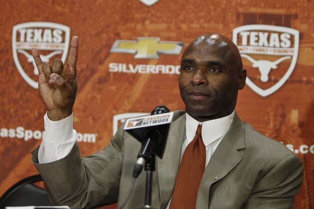 AUSTIN, TX - JANUARY 6: The University of Texas Longhorns new head football coach Charlie Strong from Louisville flashes the 'Hook 'Em Horns' sign after being introduced during a press conference January 6, 2014 at Darrell K. Royal-Texas Memorial Stadium in Austin, Texas.  (Photo by Erich Schlegel/Getty Images)
