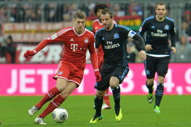 Bayern's Toni Kroos, left, and Hamburg's Rafael van der Vaart challenge for the ball   during  the German first division Bundesliga soccer match between FC Bayern Munich and Hamburger SV  in Munich, Germany, Saturday, Dec. 14, 2013. (AP Photo/Kerstin Joensson)