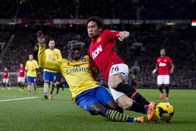 Manchester United's Shinji Kagawa, right, fights for the ball against Arsenal's Bacary Sagna during their English Premier League soccer match at Old Trafford Stadium, Manchester, England, Saturday Nov. 10, 2013. (AP Photo/Jon Super)