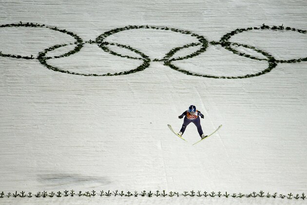 Germany's Carina Vogt jumps over the Olympic Rings on her second run during the women's normal hill ski jumping final at the 2014 Winter Olympics, Tuesday, Feb. 11, 2014, in Krasnaya Polyana, Russia. (AP Photo/Charlie Riedel)