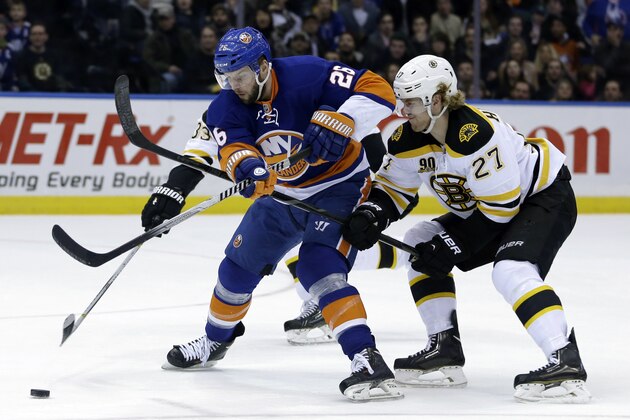 Boston Bruins' Dougie Hamilton, right, commits a hooking penalty against New York Islanders' Thomas Vanek during the second period of the NHL hockey game, Monday, Jan. 27, 2014, in Uniondale, New York. (AP Photo/Seth Wenig)