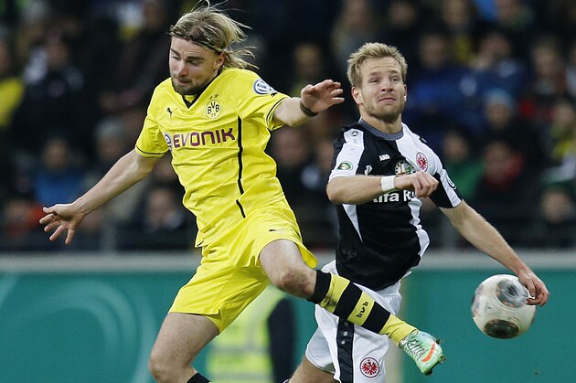 Frankfurt's Stefan Aigner, right, and Dortmund's Marcel Schmelzer challenge for the ball during a quarterfinal match of the German soccer cup between Eintracht Frankfurt and Borussia Dortmund in Frankfurt, Germany, Tuesday, Feb. 11, 2014.  (AP Photo/Michael Probst)