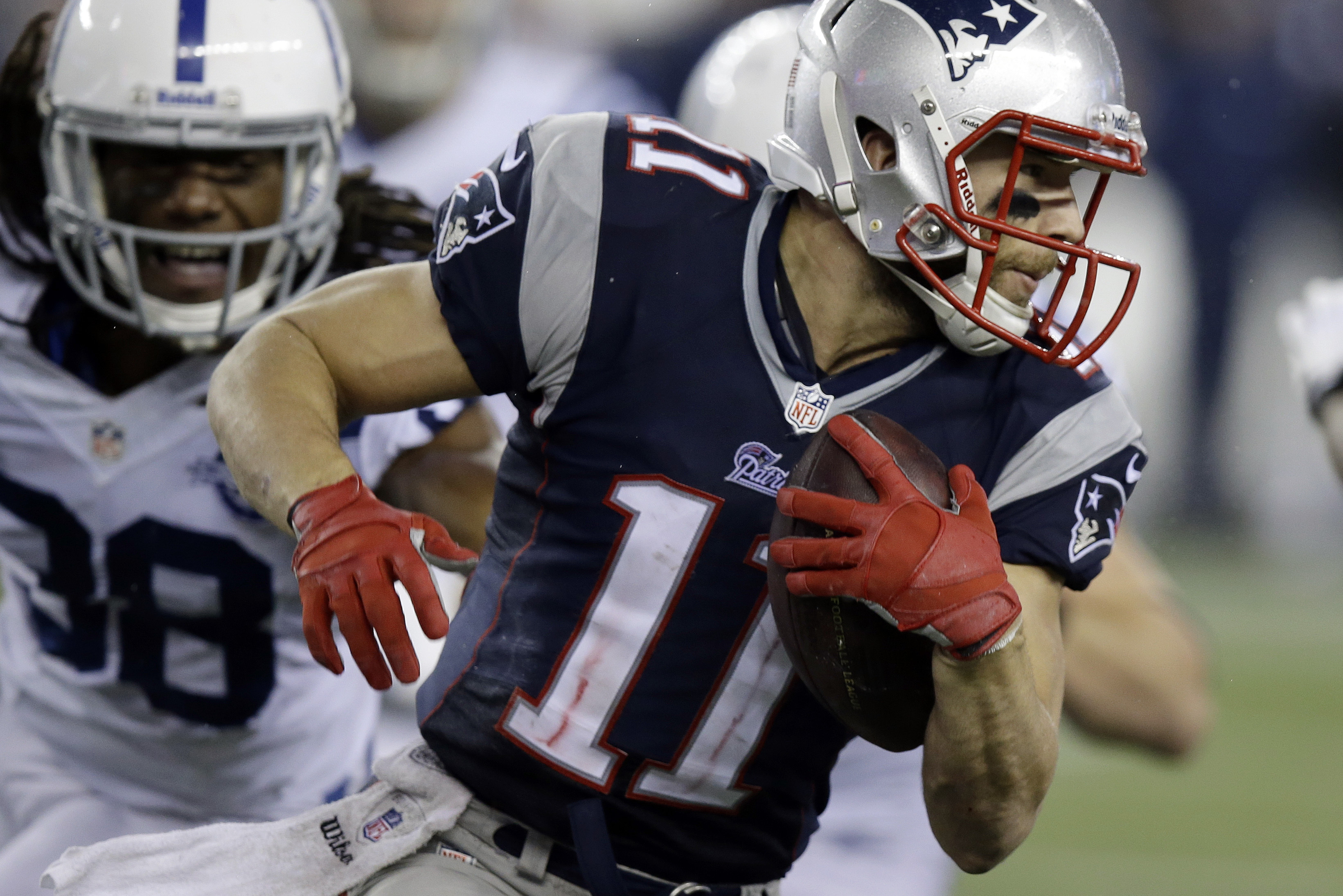 New England Patriots wide receiver Julian Edelman (11) runs from Indianapolis Colts defensive back Sergio Brown (38) after a catch during the second half of an AFC divisional NFL playoff football game in Foxborough, Mass., Saturday, Jan. 11, 2014. (AP Photo/Stephan Savoia)