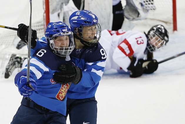 Jenni Hiirikoski of Finland, left, celebrates her game winning goal in overtime with teammate Venla Hovi, right, as Sara Benz of Switzerland looks on in the background during the 2014 Winter Olympics women's ice hockey game at Shayba Arena, Wednesday, Feb. 12, 2014, in Sochi, Russia. Finland defeated Switzerland 4-3 in overtime. (AP Photo/Petr David Josek)