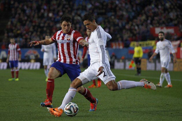 Real's Raphael Varane in action with Atletico's Cristian Rodriguez during a semi final, 2nd leg, Copa del Rey soccer derby match between Real Madrid and Atletico Madrid at the Vicente Calderon Stadium in Madrid, Tuesday Feb. 11 , 2014.  (AP Photo/Gabriel Pecot)