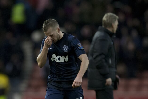 Manchester United's Tom Cleverley holds his nose after his team's 2-1 loss at Stoke in their English Premier League soccer match at the Britannia Stadium, Stoke, England, Saturday Feb. 1, 2014. (AP Photo/Jon Super)