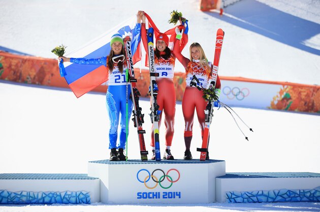 SOCHI, RUSSIA - FEBRUARY 12:  (L-R) Gold medalist Tina Maze of Slovenia, gold medalist Dominique Gisin of Switzerland and bronze medalist Lara Gut of Switzerland celebrate on the podium during the flower ceremony for during the Alpine Skiing Women's Downhill on day 5 of the Sochi 2014 Winter Olympics at Rosa Khutor Alpine Center on February 12, 2014 in Sochi, Russia.  (Photo by Richard Heathcote/Getty Images)