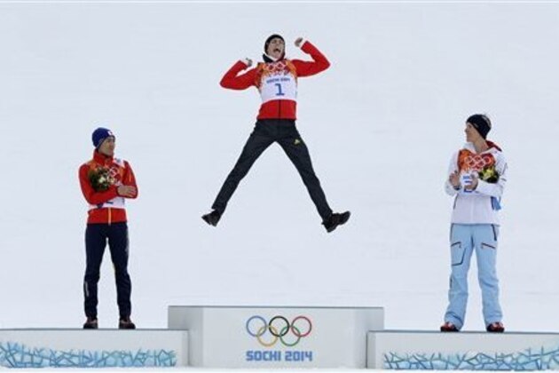Germany's Eric Frenzel celebrates winning the gold as he is flanked by Japan's silver medal winner Akito Watabe, left, and Norway's bronze medal winner Magnus Krog  during the flower ceremony after the cross-country portion of the nordic combined at the 2014 Winter Olympics, Wednesday, Feb. 12, 2014, in Krasnaya Polyana, Russia. (AP Photo/Matthias Schrader)