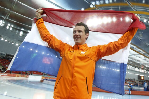 Stefan Groothuis of the Netherlands holds his national flag and celebrates after winning the gold in the men's 1,000-meter speedskating race at the Adler Arena Skating Center at the 2014 Winter Olympics in Sochi, Russia, Wednesday, Feb. 12, 2014.(AP Photo/Pavel Golovkin)