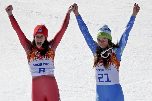 Women's downhill gold medal winners Switzerland's Dominique Gisin, left, and Slovenia's Tina Maze stand together on the podium during a flower ceremony at the Sochi 2014 Winter Olympics, Wednesday, Feb. 12, 2014, in Krasnaya Polyana, Russia. (AP  Photo/Charlie Riedel)