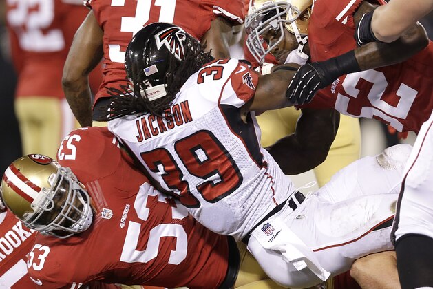 Atlanta Falcons running back Steven Jackson (39) is tackled by San Francisco 49ers linebacker NaVorro Bowman (53) and linebacker Patrick Willis (52) during the first quarter of an NFL football game in San Francisco, Monday, Dec. 23, 2013. (AP Photo/Marcio Jose Sanchez)
