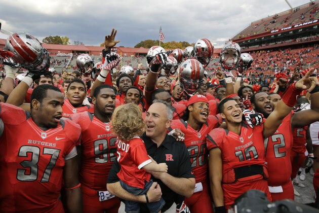 Rutgers head coach Kyle Flood, center, holds son Joseph Flood, 2,  as the team celebrates after an NCAA college football game against Temple in Piscataway, N.J. Saturday, Nov. 2, 2013. Rutgers won 23-20. (AP Photo/Mel Evans)