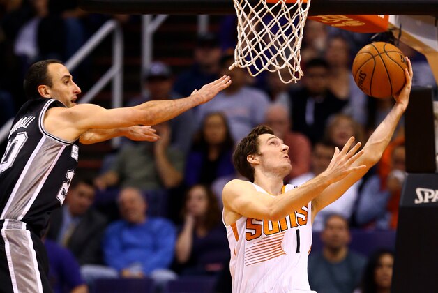 Dec 18, 2013; Phoenix, AZ, USA; Phoenix Suns guard Goran Dragic (right) takes a shot under pressure from San Antonio Spurs guard Manu Ginobili in the second quarter at US Airways Center. Mandatory Credit: Mark J. Rebilas-USA TODAY Sports
