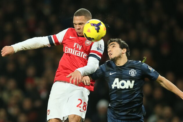 Arsenal's Kieran Gibbs, left, challenges for the ball as he out jumps Manchester United's Rafael during their English Premier League soccer match between Arsenal and Manchester United at the Emirates stadium in London, Wednesday, Feb. 12, 2014. (AP Photo/Alastair Grant)