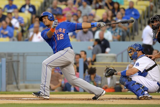 New York Mets' Juan Lagares follows through on a solo home run as Los Angeles Dodgers catcher A.J. Ellis and home plate umpire Jeff Kellogg watch during the first inning of a baseball game, Tuesday, Aug. 13, 2013, in Los Angeles. (AP Photo/Mark J. Terrill)