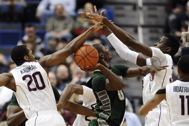 Connecticut's Lasan Kromah, left, and Amida Brimah, right, block a shot-attempt by South Florida's Martino Brock, center, during the first half of an NCAA college basketball game on Wednesday, Feb. 12, 2014, in Hartford, Conn. (AP Photo/Jessica Hill)