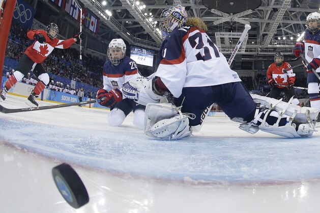 Goalkeeper Jessie Vetter and Kendall Coyne (26) of the United States look back at the puck as Meghan Agosta-Marciano, left, of Canada celebrates her goal during women's ice hockey game at the 2014 Winter Olympics, Wednesday, Feb. 12, 2014, in Sochi, Russia. Canada defeated the United States 3-2. (AP Photo/Matt Slocum, Pool)