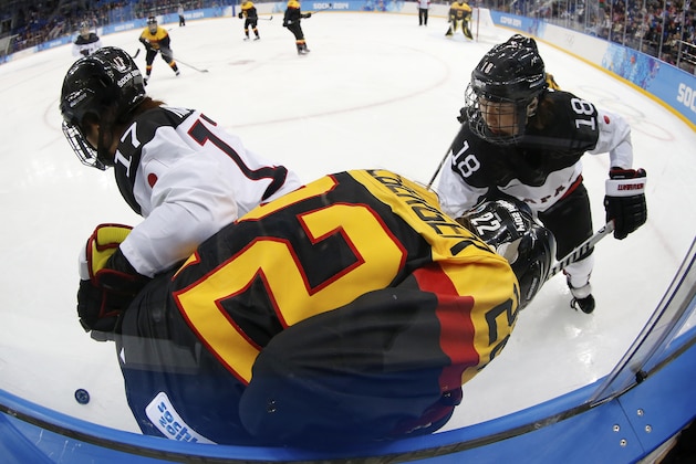 Yuka Hirano (17) and Tomoko Sakagami (18) of Japan battle up against the boards with Kerstin Spielberger of Germany during the 2014 Winter Olympics women's ice hockey game at Shayba Arena, Thursday, Feb. 13, 2014, in Sochi, Russia. (AP Photo/Petr David Josek)