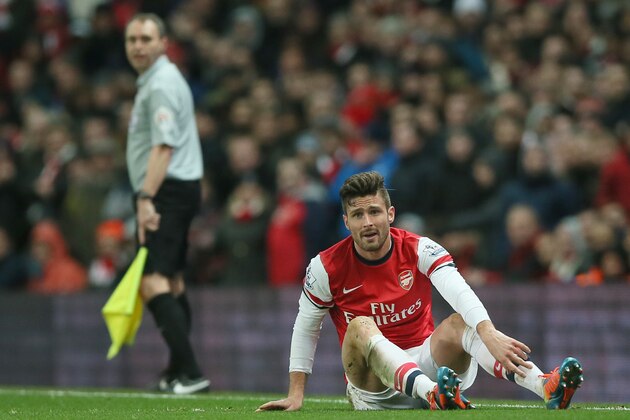 Arsenal Oliver Giroud lies on the ground following a hard tackle during the English Premier League soccer match between Arsenal and Manchester United at the Emirates stadium in London, Wednesday, Feb. 12, 2014.The game ended 0-0 draw.  (AP Photo/Alastair Grant)