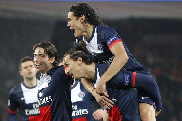 PSG's Zlatan Ibrahimovic, center, carries teammate Edinson Cavani after Ibrahimovic scored the opening goal during the Group C Champions League soccer match between Paris Saint Germain and Olympiakos FC at the Parc des Princes stadium in Paris, Wednesday, Nov.27, 2013. (AP Photo/Michel Euler)