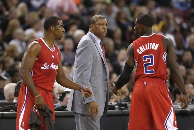 Los Angeles Clippers' Chris Paul, left, and Darren Collison, right, talk as head coach Doc Rivers looks on during the first quarter against the Sacramento Kings in a NBA basketball game in Sacramento, Calif., Friday, Nov. 1, 2013.(AP Photo/Rich Pedroncelli)