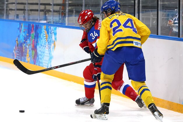 SOCHI, RUSSIA - FEBRUARY 13: Svetlana Tkachyova #34 of Russia handles the puck against Erika Grahm #24 of Sweden in the first period during the Women's Ice Hockey Preliminary Round Group B game on day six of the Sochi 2014 Winter Olympics at Shayba Arena on February 13, 2014 in Sochi, Russia.  (Photo by Martin Rose/Getty Images)