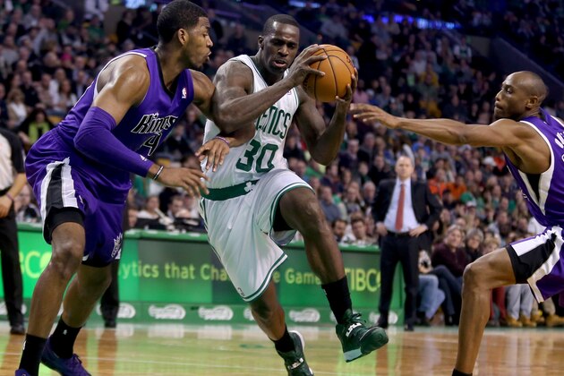 Boston Celtics power forward Brandon Bass (30) drives between Sacramento Kings defenders during the first half of an NBA basketball game, Friday, Feb. 7, 2014 in Boston. (AP Photo/Mary Schwalm)