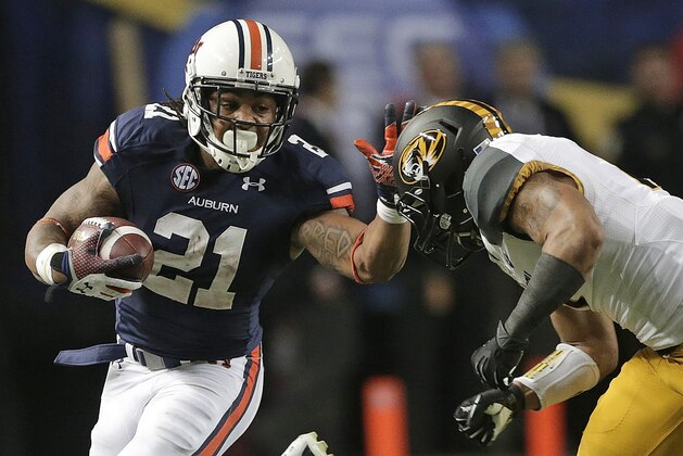 FILE - In this Dec. 7, 2013, file photo, Auburn running back Tre Mason (21) reaches out to fend off  Missouri defensive back Randy Ponder (7) during the second half of the Southeastern Conference championship NCAA college football game in Atlanta. Mason is one of six finalist for the Heisman Trophy, which will be presented on Saturday, Dec. 14, 2013, in  New York. (AP Photo/Dave Martin, File)