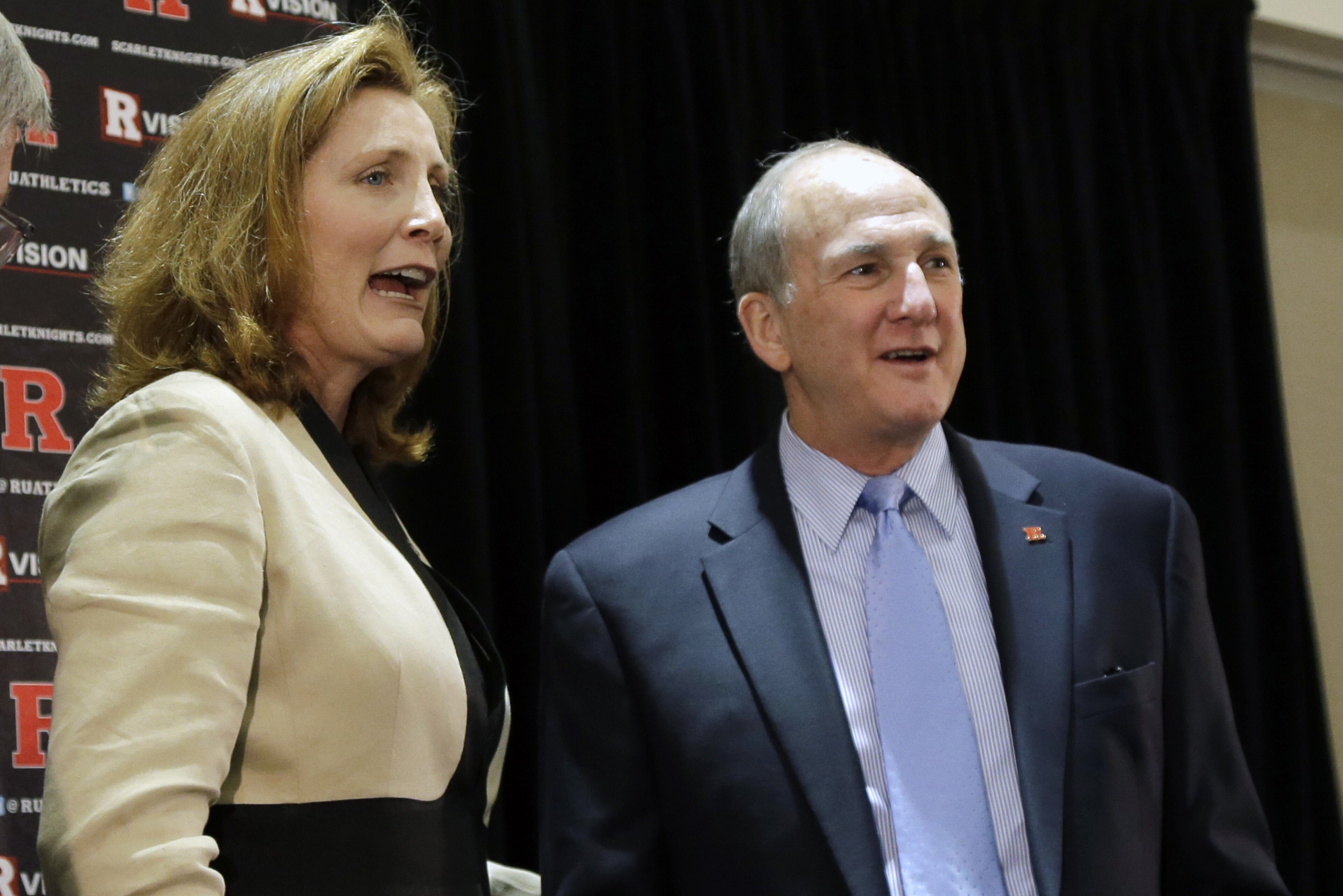 In this Wednesday, May 15, 2013, photograph, Julie Hermannan, left, stands with Rutgers President Robert L. Barchi, as they listen to a questionn at Rutgers University in Piscataway, N.J., after she was introduced as Rutgers' new athletic director to succeed Tim Pernetti, who resigned last month in the wake of the scandal involving men's basketball coach Mike Rice. Hermann, the University of Louisville's senior associate athletic director, will be the third female athletic director at a school among the 124 playing at college football's top tier. (AP Photo/Mel Evans)