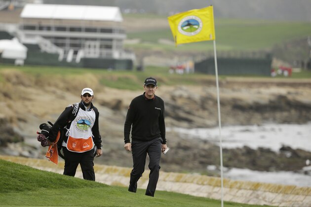 Jimmy Walker, right, walks with his caddie to the 18th green of the Pebble Beach Golf Links during the final round of the AT&T Pebble Beach Pro-Am golf tournament Sunday, Feb. 9, 2014, in Pebble Beach, Calif. (AP Photo/Eric Risberg)
