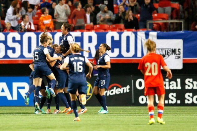 ATLANTA, GA - FEBRUARY 13:  Abby Wambach #20 of the United States leaps above her teammates as they celebrate an own goal by the Russian defense at Georgia Dome on February 13, 2014 in Atlanta, Georgia.  (Photo by Kevin C. Cox/Getty Images)